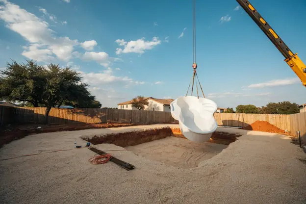 Fiberglass pool shell being craned into a Texas backyard